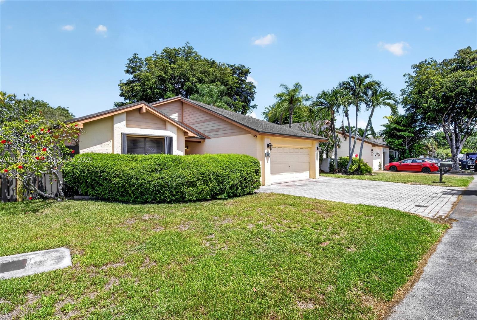 A single-story house with a beige exterior, a paved driveway, and a large front hedge — 5212 SW 151st Pl, Miami FL 33185, MIAMI, FL