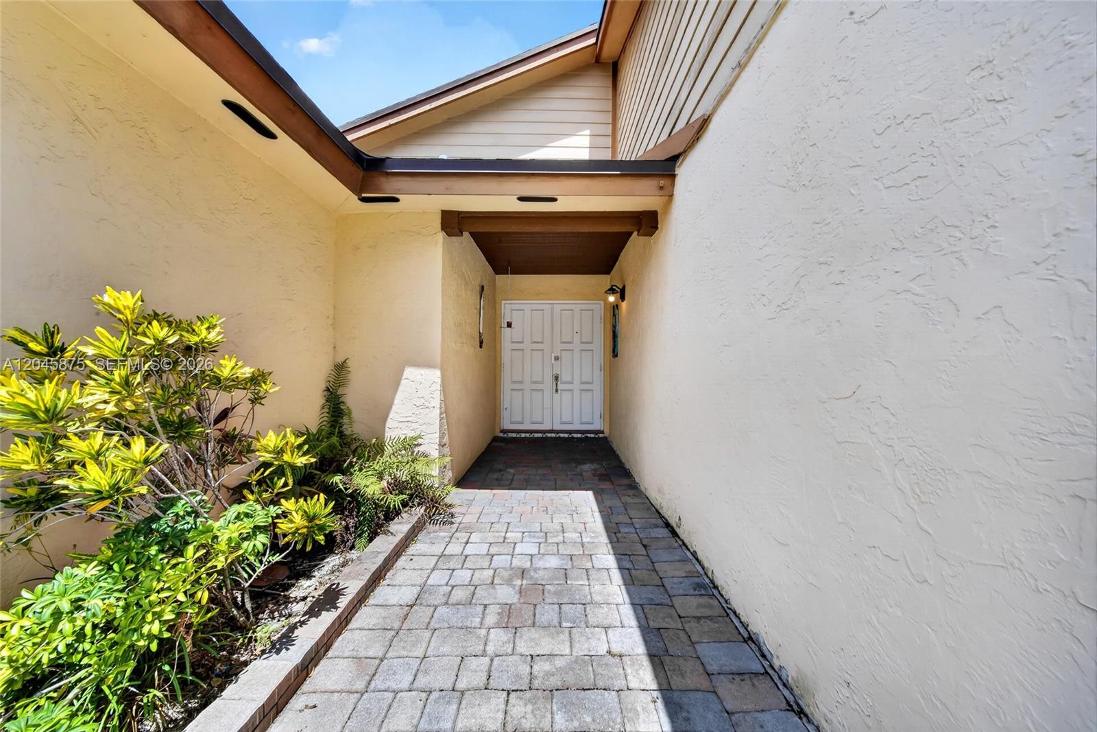 A paved walkway leads to a double-door entrance recessed between two beige stucco walls — 5212 SW 151st Pl, Miami FL 33185, MIAMI, FL