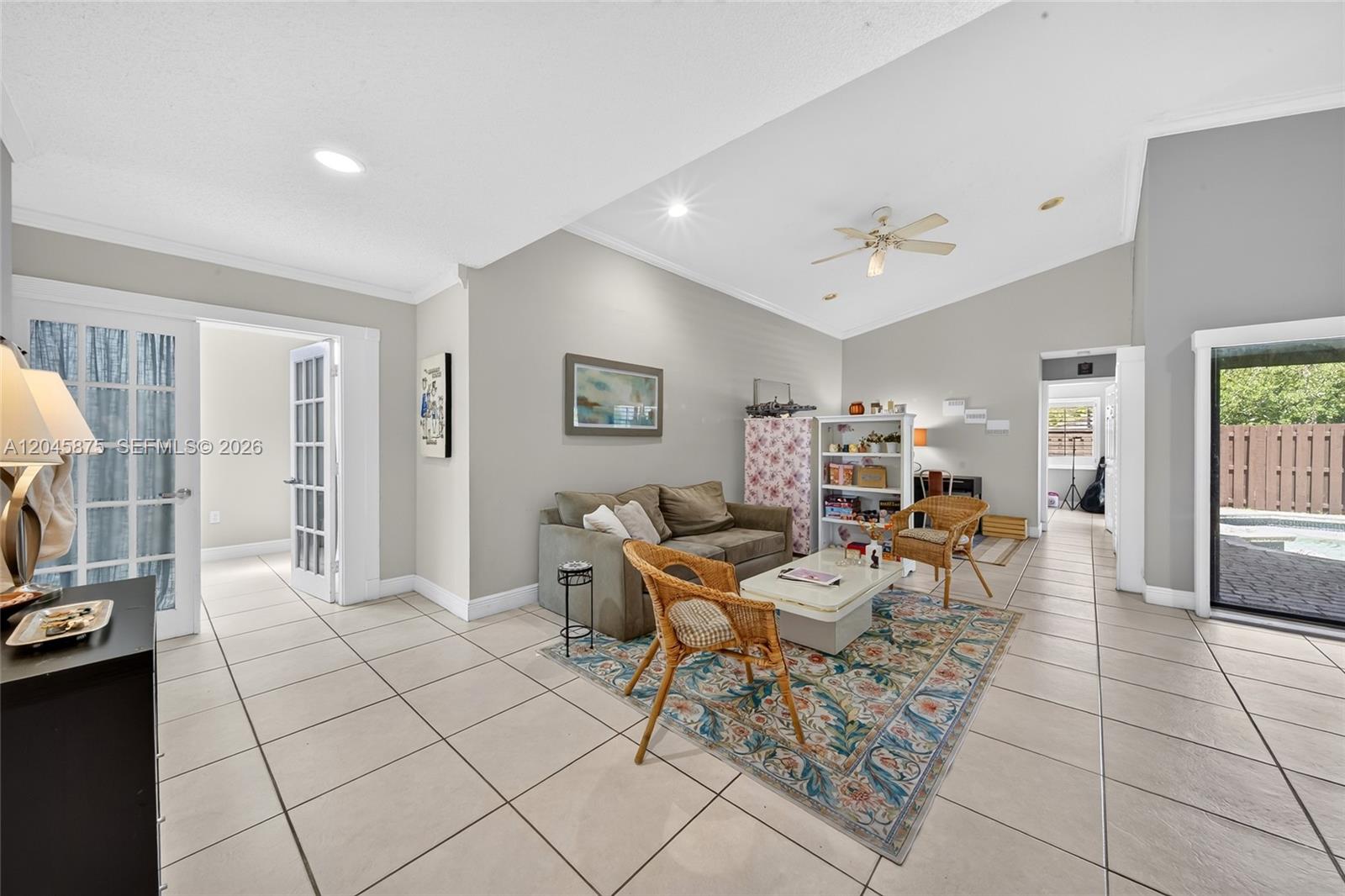 A living room features tile flooring, a vaulted ceiling, a sofa, and a sliding glass door — 5212 SW 151st Pl, Miami FL 33185, MIAMI, FL