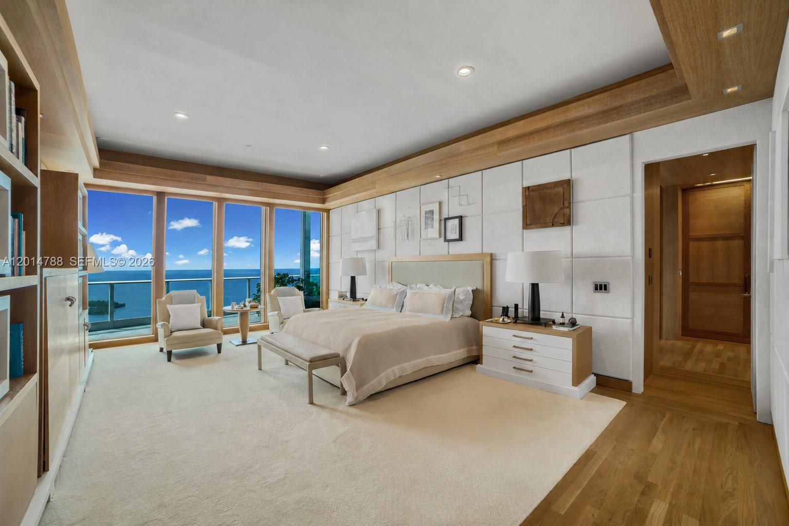 A modern bedroom features a king bed, white paneled walls, and floor-to-ceiling ocean view windows — 2627 S Bayshore Dr # 3201, Miami FL 33133, MIAMI, FL