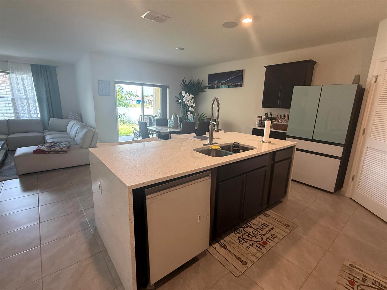 A kitchen island with a sink and dishwasher sits in an open-concept living space — 1405 Pace Drive NW, Palm Bay FL 32907, PALM BAY, FL