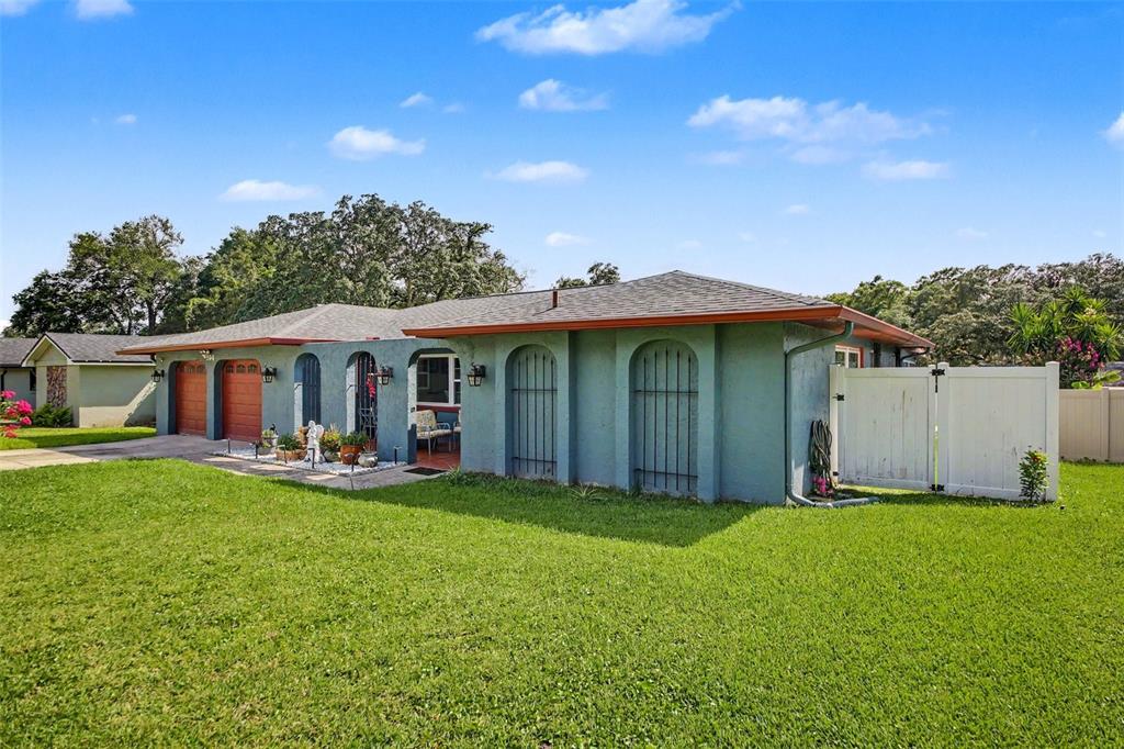 A single-story house with a green stucco exterior, arched windows, and an attached two-car garage — 394 BARBERRY LANE, ALTAMONTE SPRINGS, FL