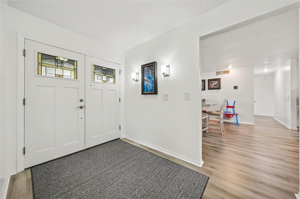 An entryway with a white front door, gray area rug, and light wood-look flooring — 394 BARBERRY LANE, ALTAMONTE SPRINGS, FL
