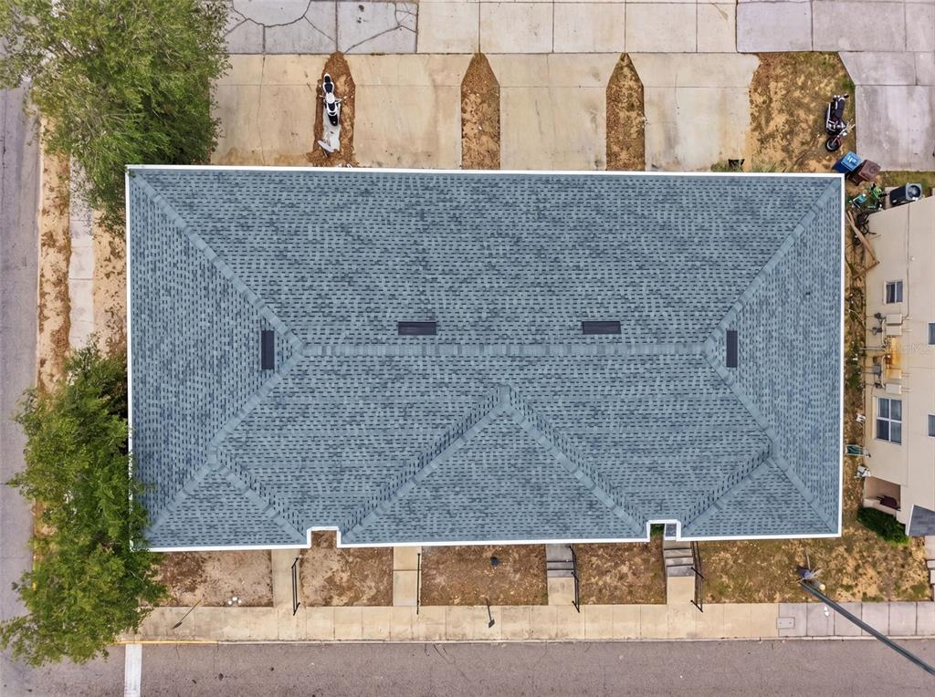 An aerial view shows the shingled roof of a rectangular building with several skylights — 963 E MAIN STREET, HAINES CITY, FL