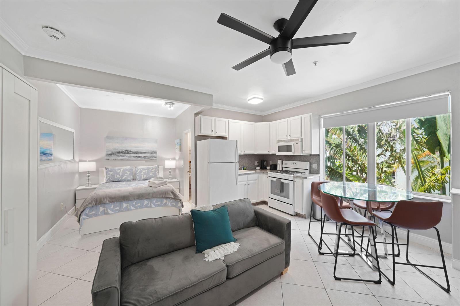 An open-concept studio apartment features a kitchen, living area, and bedroom with tile flooring — 3710 Collins Avenue # 304, Miami Beach FL 33140, MIAMI BEACH, FL