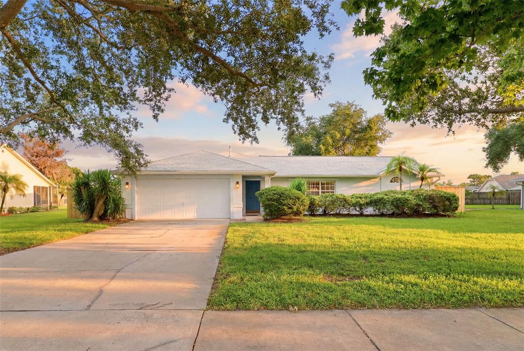 A single-story house with a white garage, blue front door, and a grassy front yard — 3065 PINEDA CROSSING DRIVE, MELBOURNE, FL