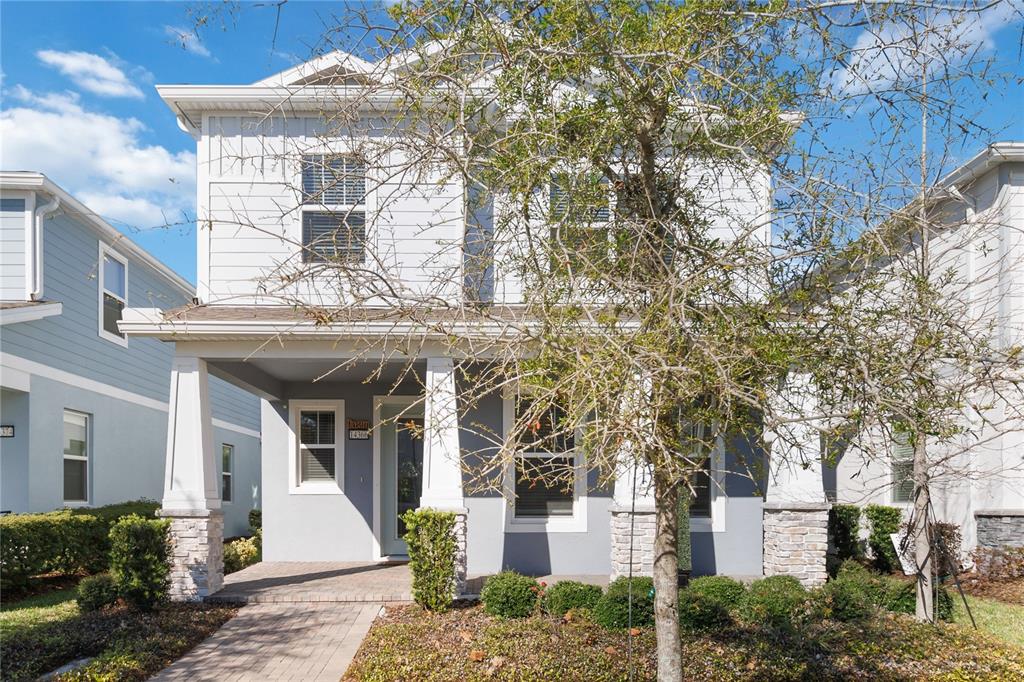 A two-story house with light gray siding, a covered front porch, and stone-based columns — 14366 LANIKAI BEACH DRIVE, ORLANDO, FL