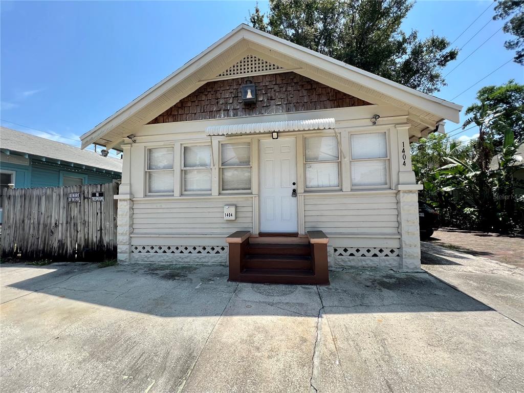 A single-story house with light-colored siding, a front porch, and a brown shingled gable — 540 14TH STREET N, ST PETERSBURG, FL