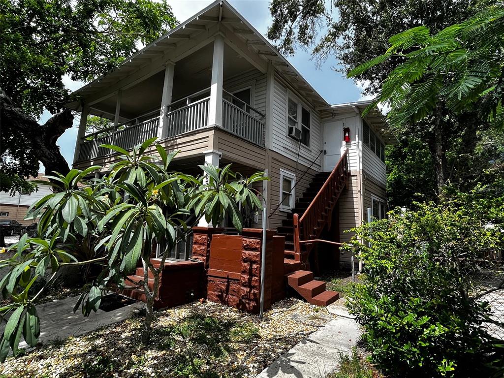 A two-story house with a wooden staircase leading to an upper-level porch — 540 14TH STREET N, ST PETERSBURG, FL
