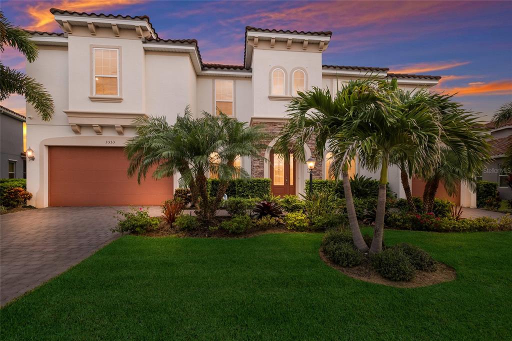 A two-story stucco house with a multi-car garage and palm trees in the front yard — 3533 BIG SKY WAY, LAKEWOOD RANCH, FL
