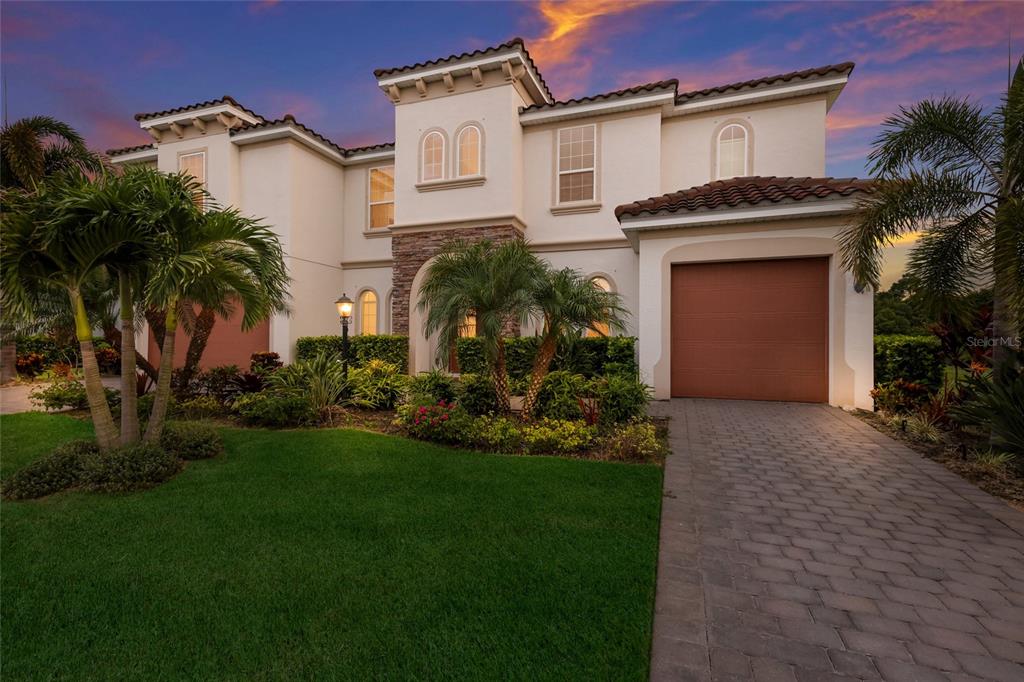 A two-story stucco house with a tile roof, arched windows, and a paved driveway — 3533 BIG SKY WAY, LAKEWOOD RANCH, FL