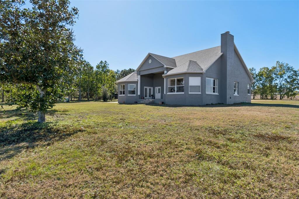 A gray, single-story house with a chimney stands on a large, grassy lot — 2307 CASS ROAD, LAKE ALFRED, FL
