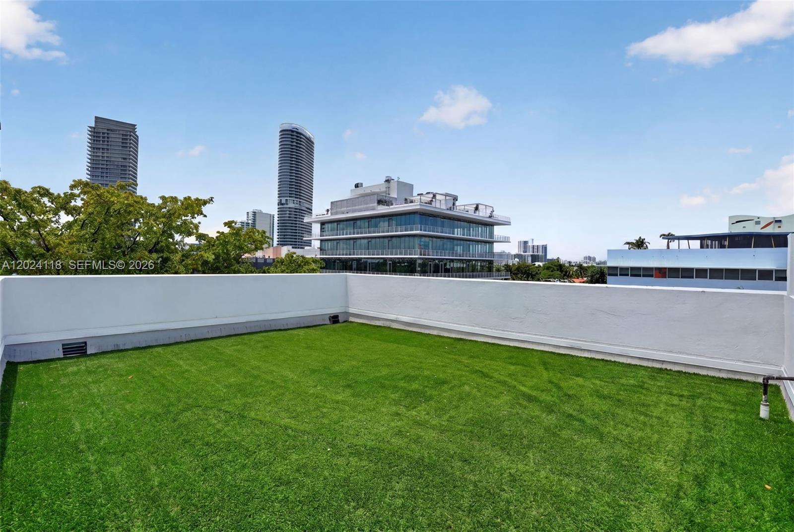 A rooftop terrace features artificial turf flooring enclosed by a white perimeter wall — 900 4th St # 6, Miami Beach FL 33139, MIAMI BEACH, FL