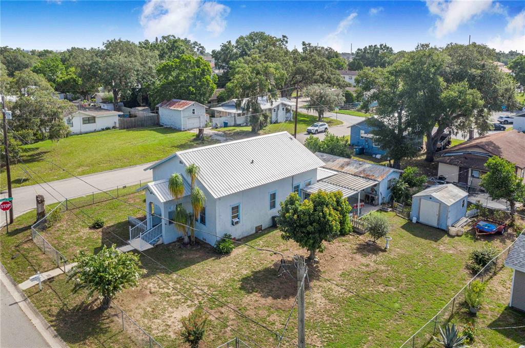 An aerial view shows a light blue house with a metal roof and a detached shed — 229 N 13TH STREET, HAINES CITY, FL