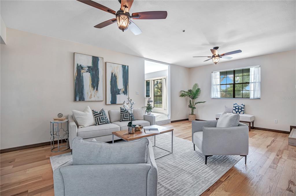 A living room features light hardwood floors, two ceiling fans, a sofa, and two armchairs — 1898 ODHAM DRIVE, DELTONA, FL