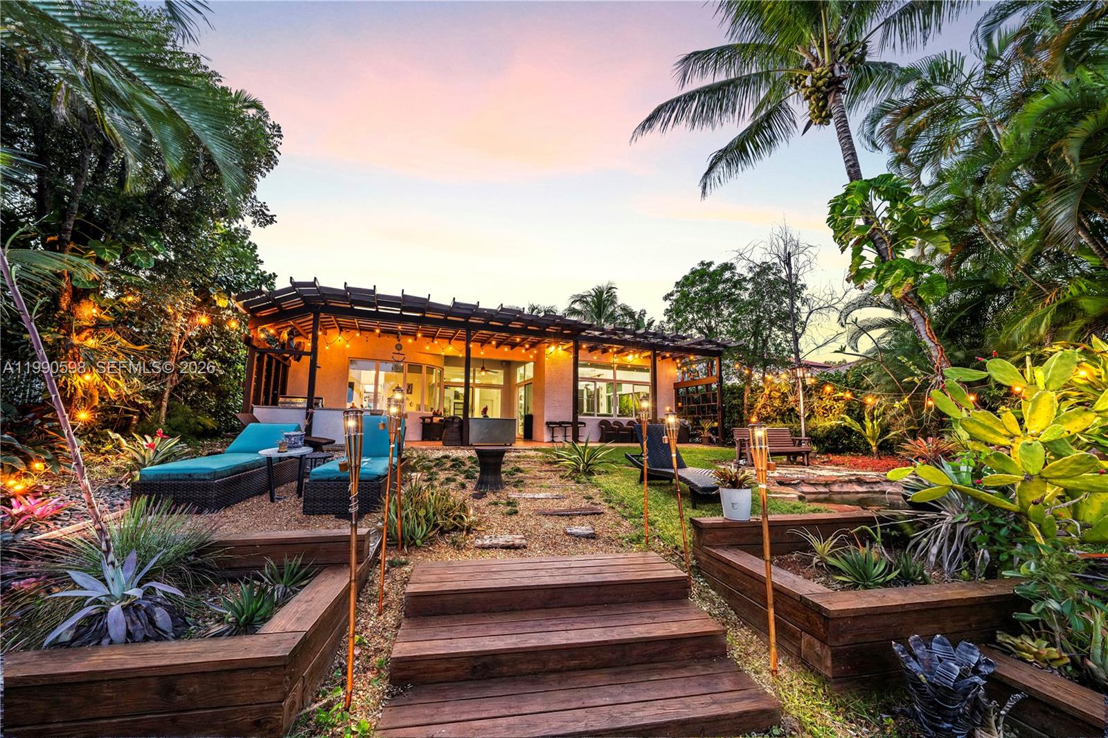 A backyard patio features a wooden pergola, gravel path, and raised garden beds at sunset — 5265 SW 171st Ave, Miramar FL 33027, MIRAMAR, FL