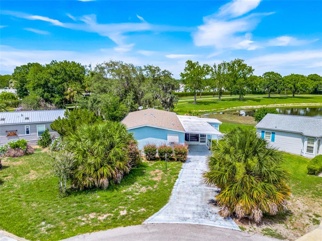 An aerial view shows a light blue house with a driveway between two palm trees — 25224 WILD HERON, LEESBURG, FL