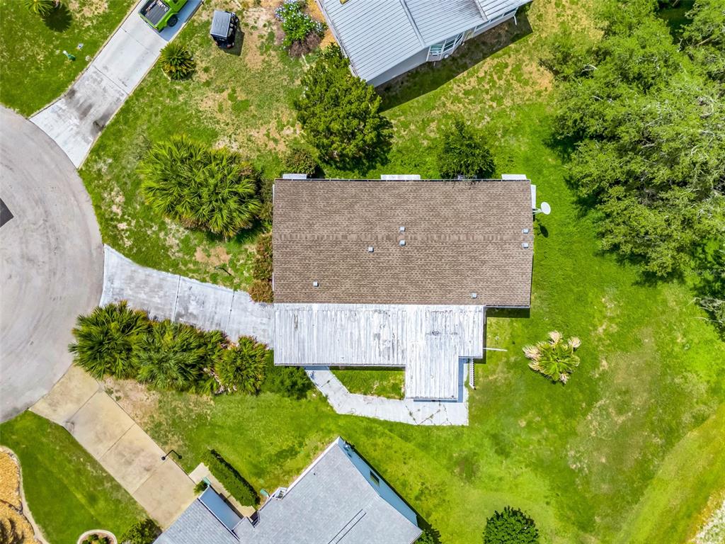 An aerial view shows a house with a shingled roof and a white patio cover — 25224 WILD HERON, LEESBURG, FL