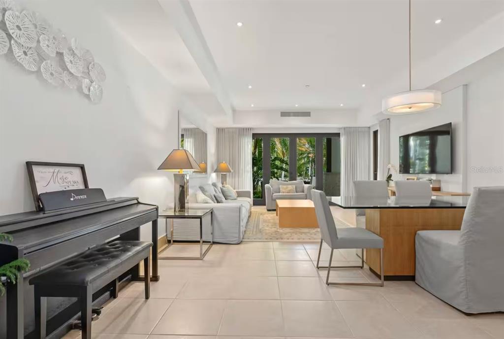 A living and dining area with a piano, light tile floors, and glass patio doors — 7000 Bahia Beach Blv LAS VERANDAS UNIT 5138, RIO GRANDE, PR