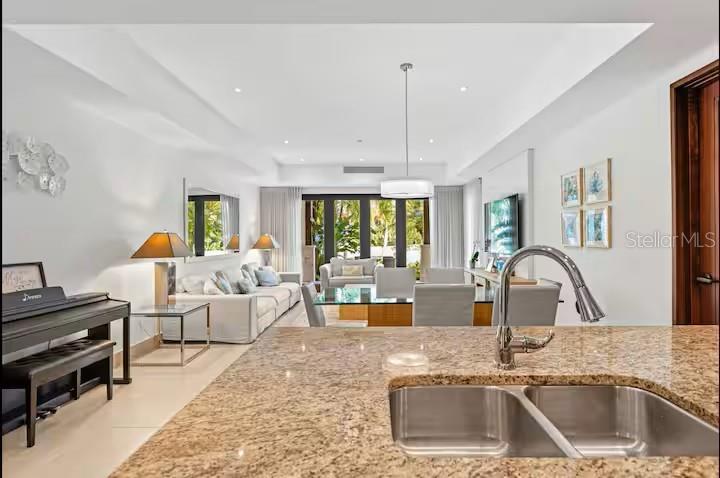 A kitchen island with a double sink overlooks an open-concept living and dining area — 7000 Bahia Beach Blv LAS VERANDAS UNIT 5138, RIO GRANDE, PR