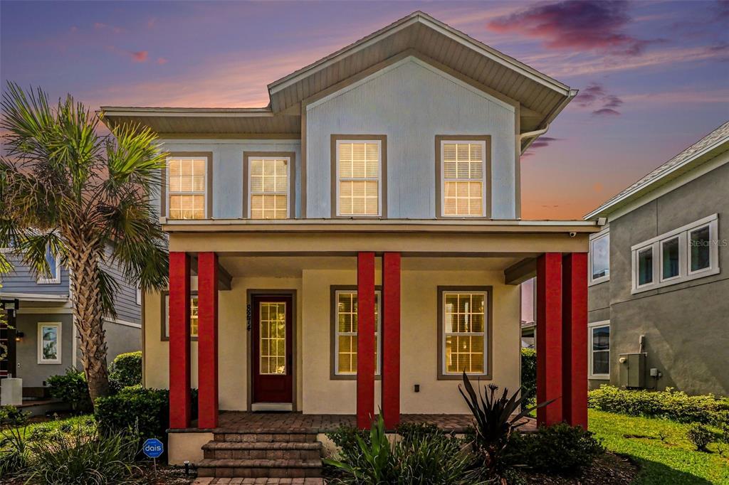 A two-story house with a covered front porch featuring red columns and a brick walkway — 8274 NEMOURS PARKWAY, ORLANDO, FL