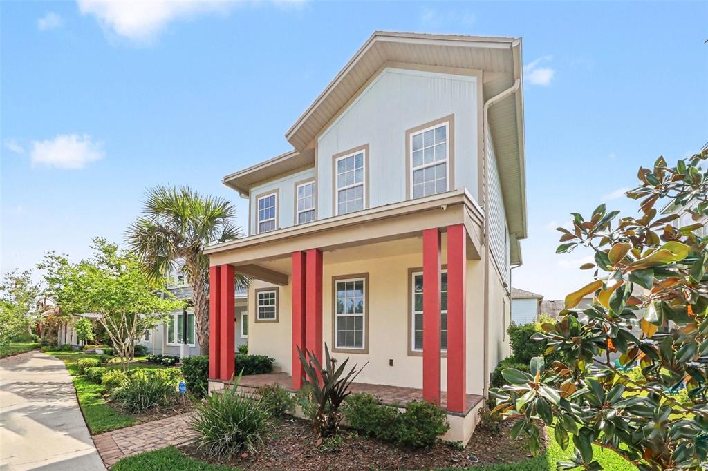 A two-story house with a covered front porch featuring red columns and light-colored siding — 8274 NEMOURS PARKWAY, ORLANDO, FL