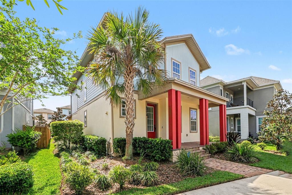 A two-story house with a palm tree, red front door, and red porch columns — 8274 NEMOURS PARKWAY, ORLANDO, FL