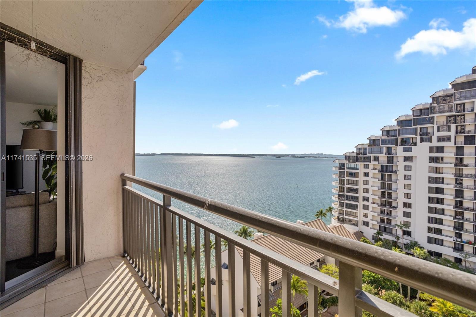 A balcony with a metal railing overlooks a large body of water and nearby buildings — 540 Brickell Key Dr # 1519, Miami FL 33131, MIAMI, FL