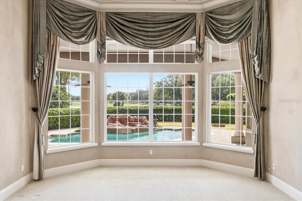 A backyard putting green with a pool, a golf statue, and a golf course view — 6102 S HAMPSHIRE COURT, WINDERMERE, FL