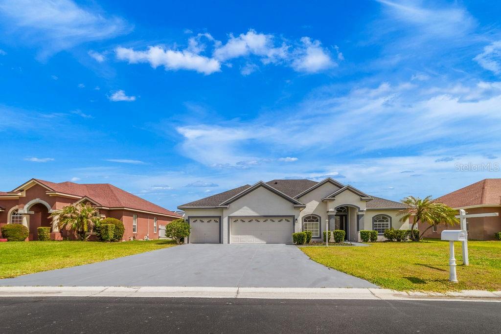 A single-story suburban house with a three-car garage and a concrete driveway — 258 TERRANOVA BOULEVARD, WINTER HAVEN, FL