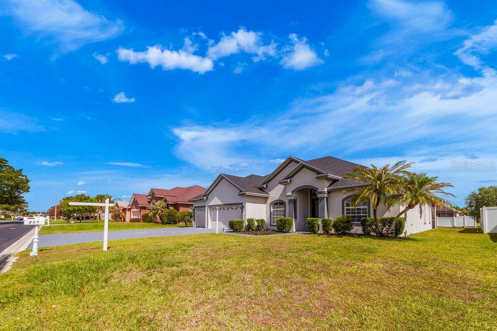 A single-story suburban house with a two-car garage and a palm tree in front — 258 TERRANOVA BOULEVARD, WINTER HAVEN, FL