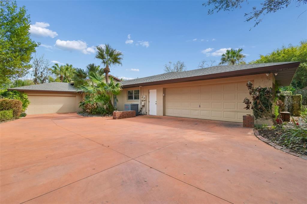 A single-story house with a large orange concrete driveway and two separate garage doors — 5324 WOODHAVEN LANE, LAKELAND, FL