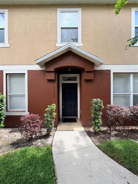 The exterior of a two-story townhouse features a dark brown entryway with a black door — 1521 SAN JACINTO CIRCLE, SANFORD, FL
