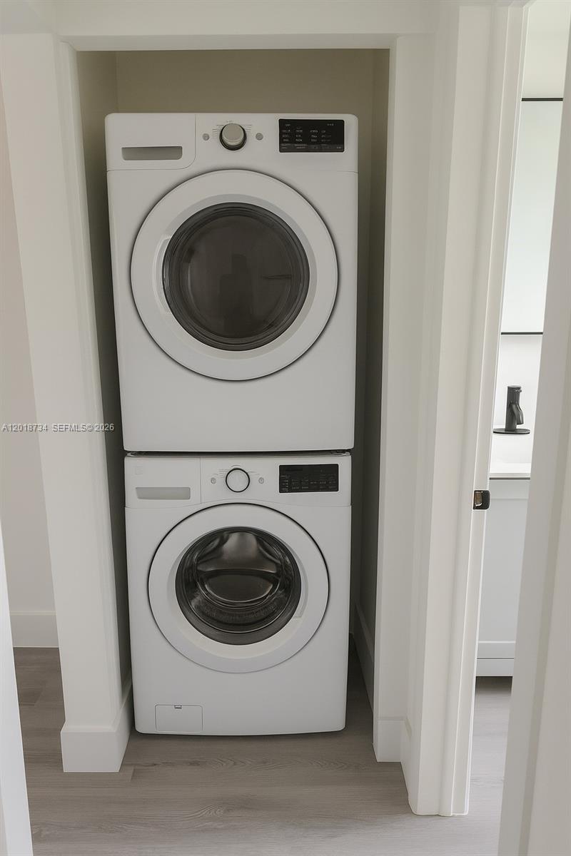 A white stacked washer and dryer unit is installed in a small closet — 417 NW 2nd Ave # 9, Hallandale Beach FL 33009, HALLANDALE BEACH, FL