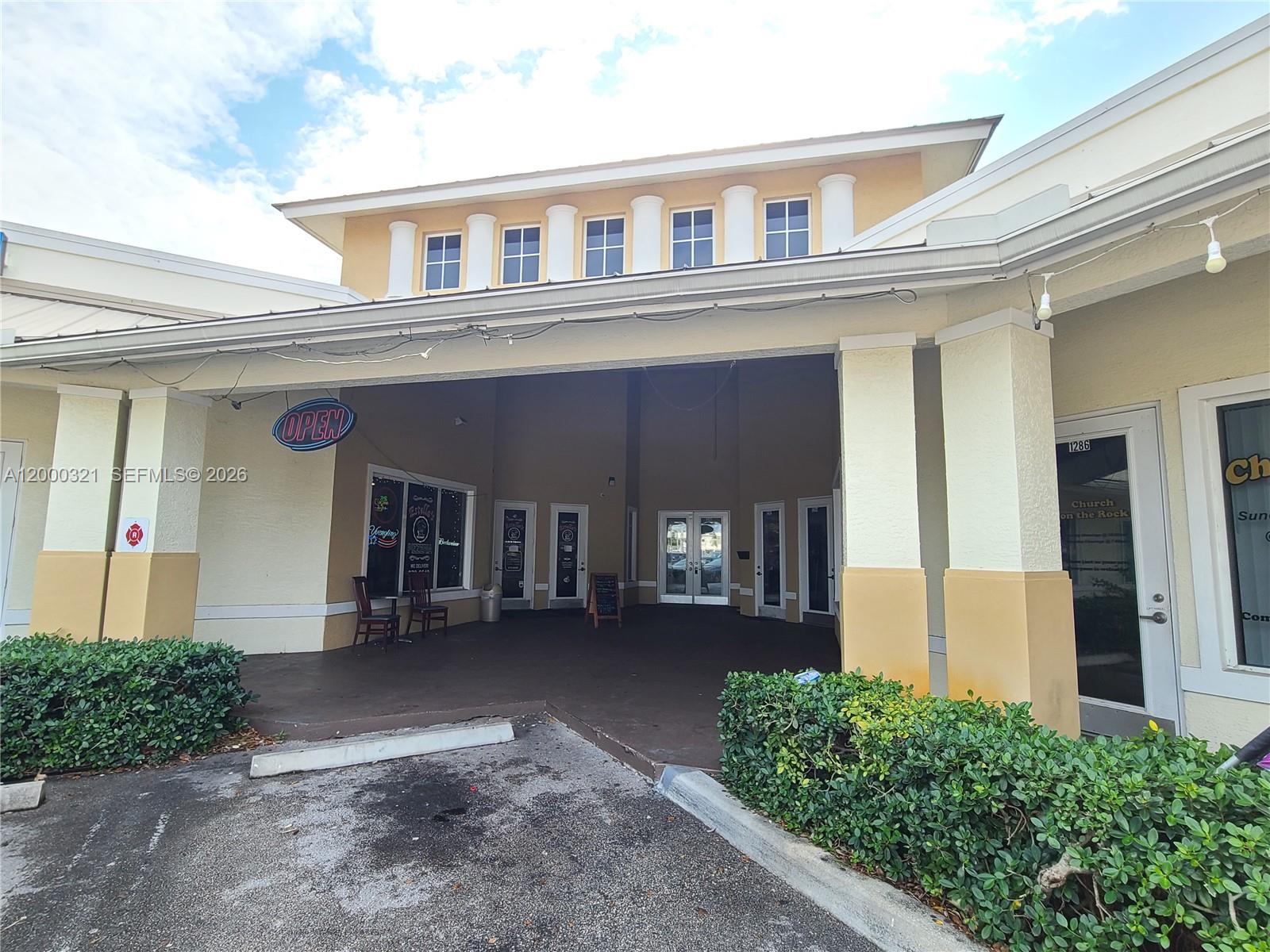 The exterior view shows a commercial building entrance with a covered walkway and columns — 1264 SW California Blvd # 1282, FL 34953, FL