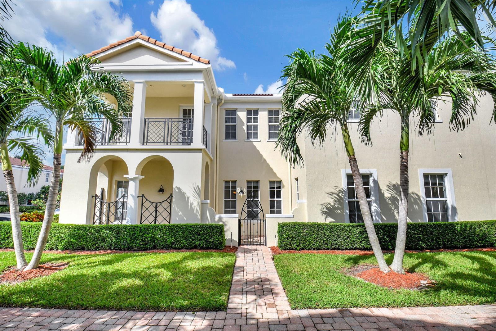 A two-story stucco house with a balcony, arched entryway, and palm trees in the yard — 838 NW 83rd Lane, Boca Raton FL 33487, BOCA RATON, FL