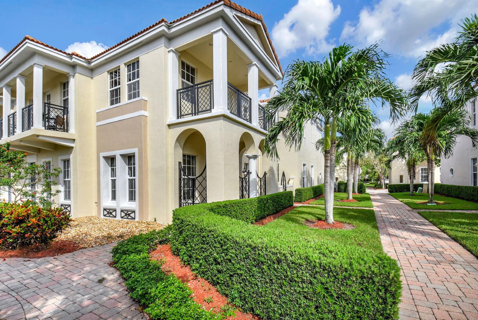 A two-story beige building with balconies and arched entryways sits beside a brick walkway — 838 NW 83rd Lane, Boca Raton FL 33487, BOCA RATON, FL