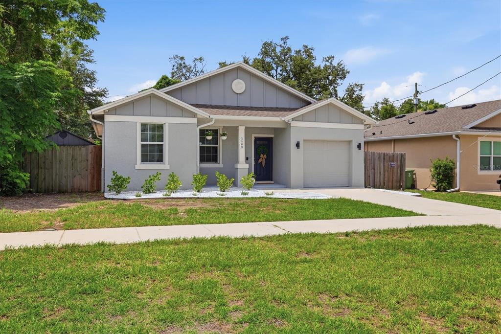 A single-story house with a gray exterior, a front porch, and a concrete driveway — 3509 E 10TH AVENUE, TAMPA, FL