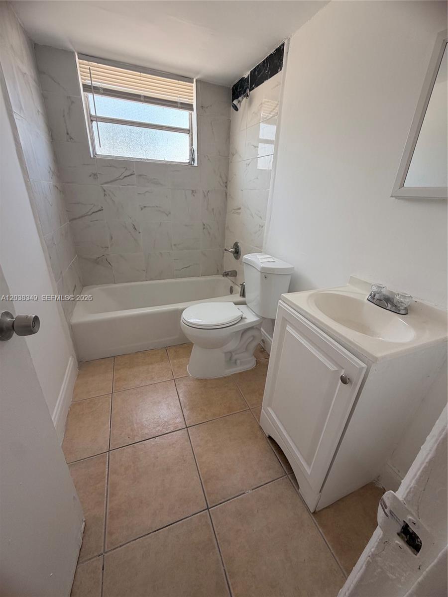 A small bathroom features a white vanity, a toilet, and a tiled tub-shower combination — 8450 NE Miami Ct # 4, Miami FL 33138, MIAMI, FL