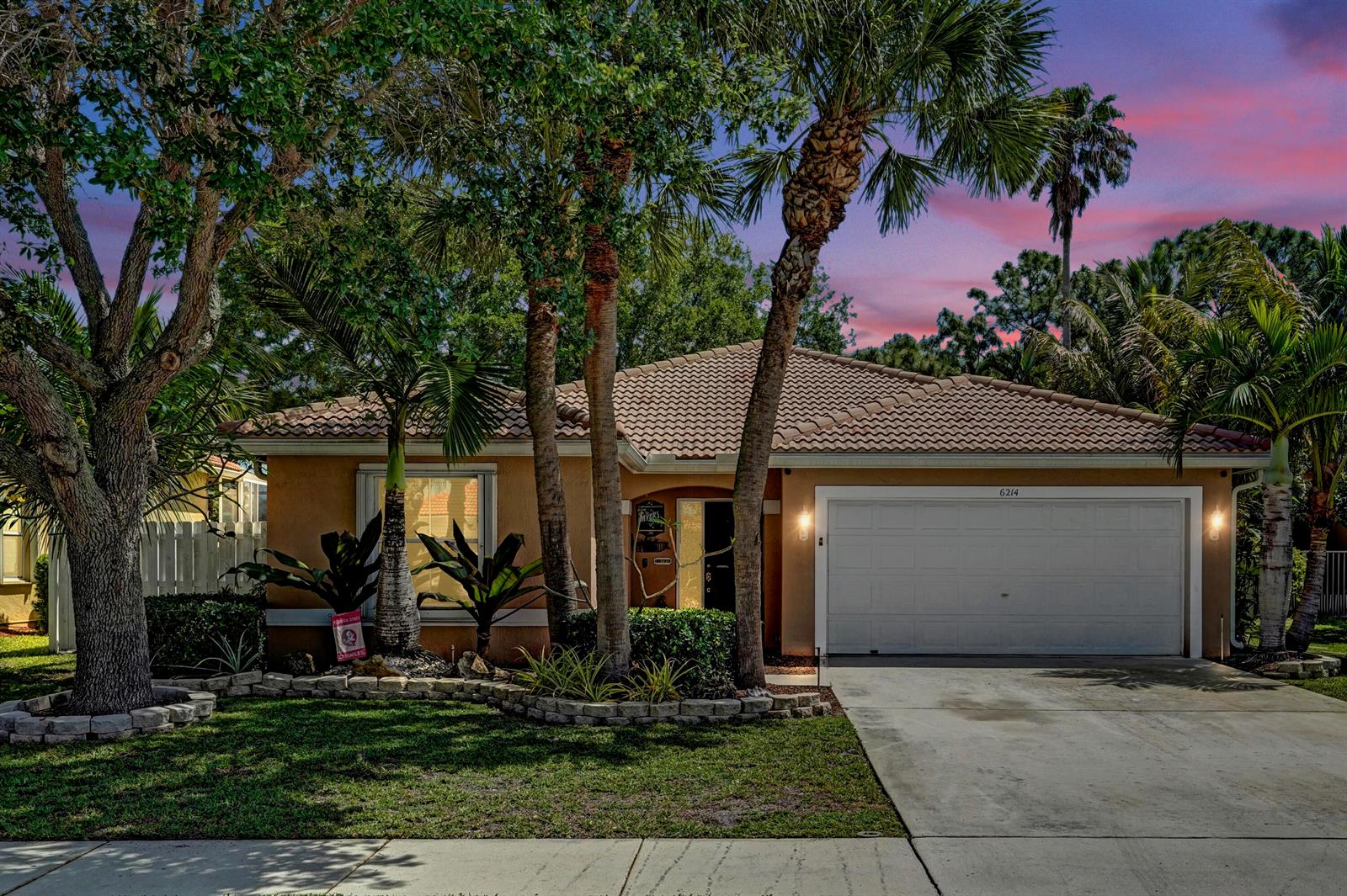 A single-story house with a tiled roof, a two-car garage, and palm trees in front — 6214 Sand Hills Circle, Lake Worth FL 33463, LAKE WORTH, FL