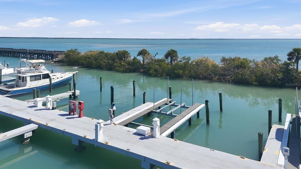 A view of a boat slip and dock overlooking a bay with a boat nearby — 5820 GASPARILLA ROAD UNIT SLIP 25, BOCA GRANDE, FL
