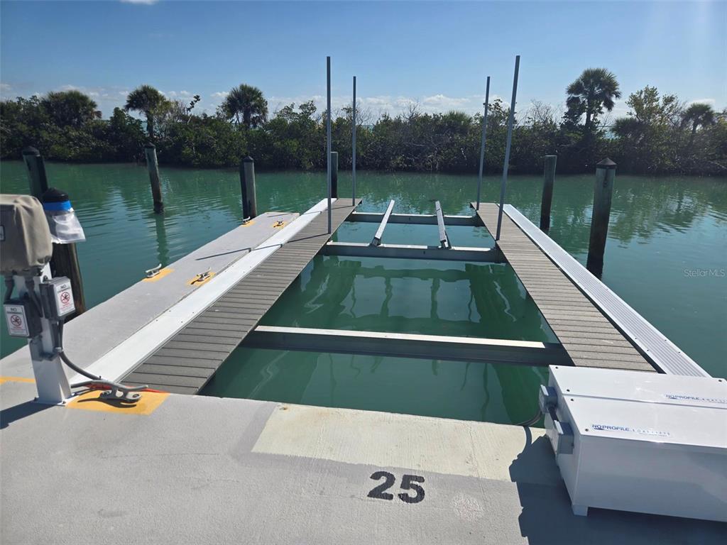 A boat slip with a mechanical lift system and wooden decking at a waterfront dock — 5820 GASPARILLA ROAD UNIT SLIP 25, BOCA GRANDE, FL