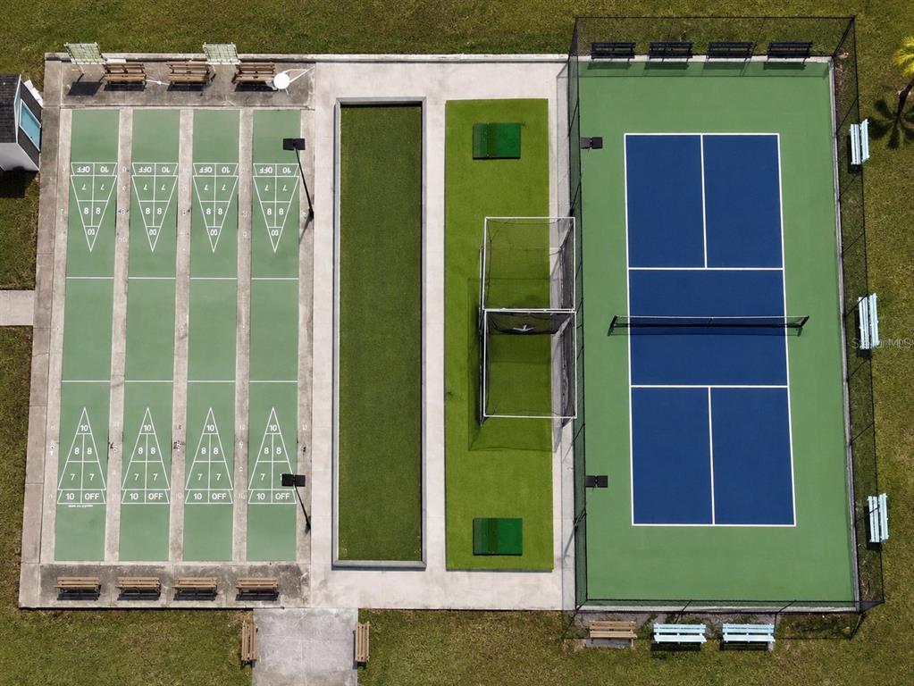 An aerial view shows four shuffleboard courts, a putting green, and a fenced pickleball court — 10151 HAMP DRIVE, DADE CITY, FL