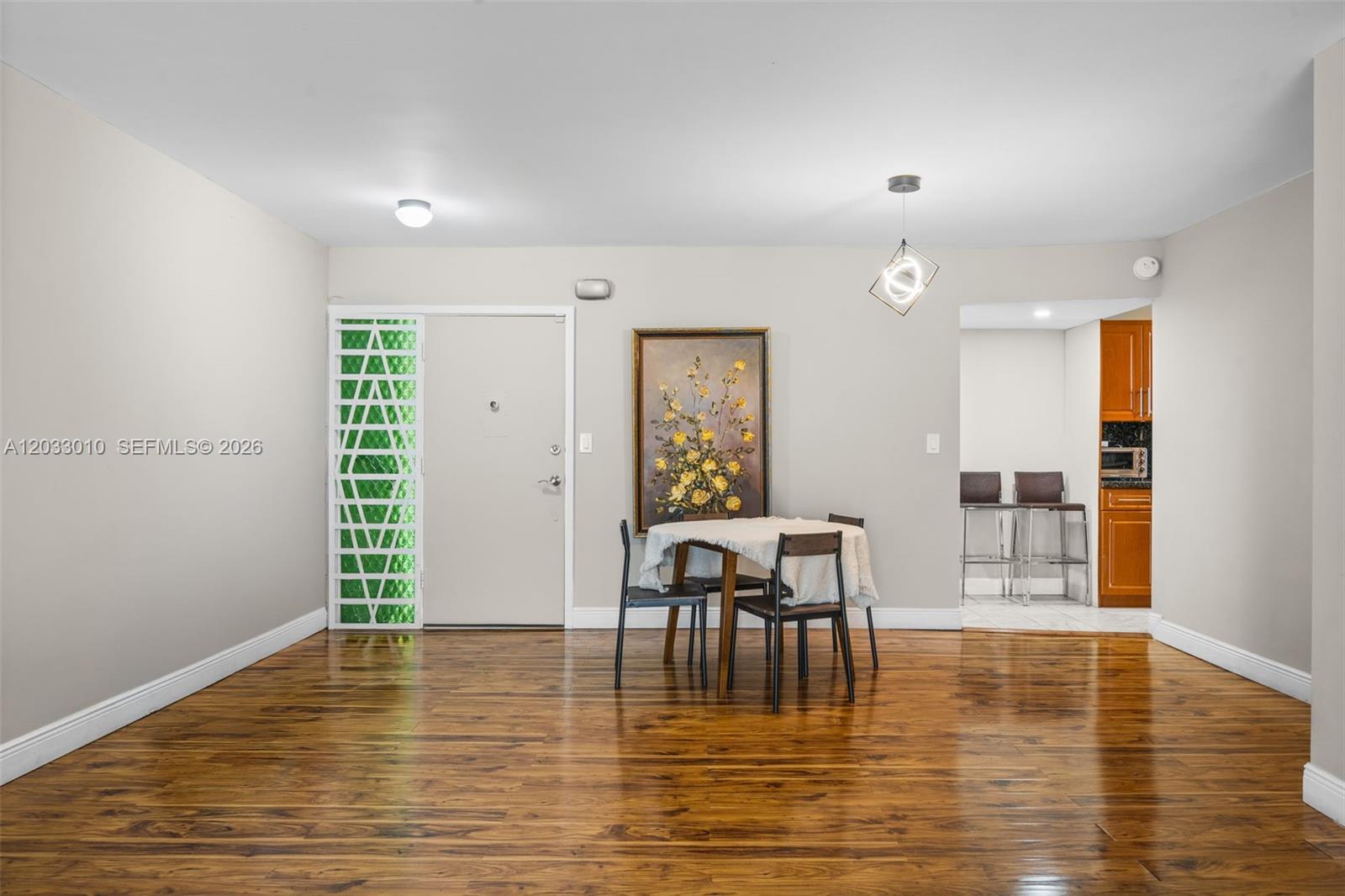 A dining area with wood flooring, a small table, and an adjacent kitchen — 1690 NE 191st St # 1, Miami FL 33179, MIAMI, FL