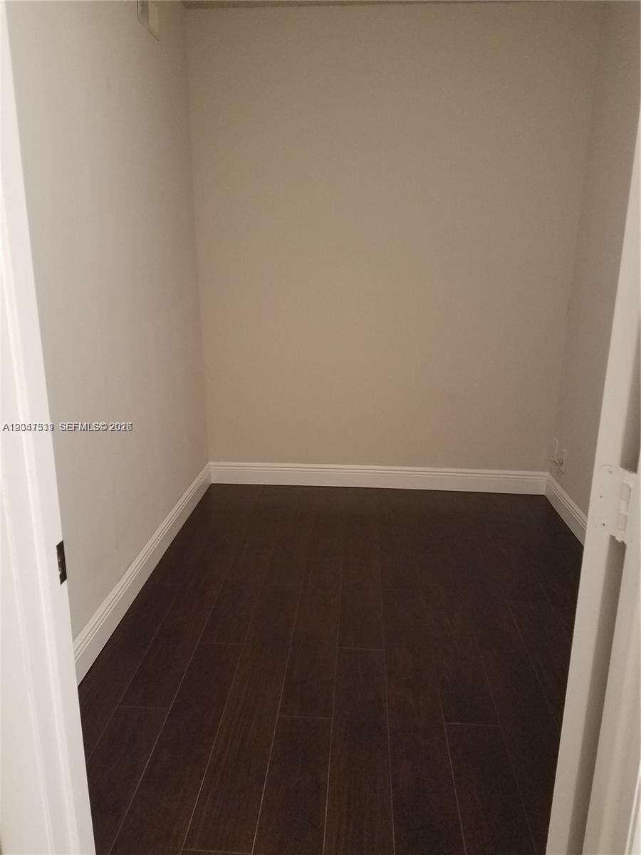 This is a small, empty closet or storage room with dark wood-look flooring — 331 Lakeview Dr # 203, Weston FL 33326, WESTON, FL