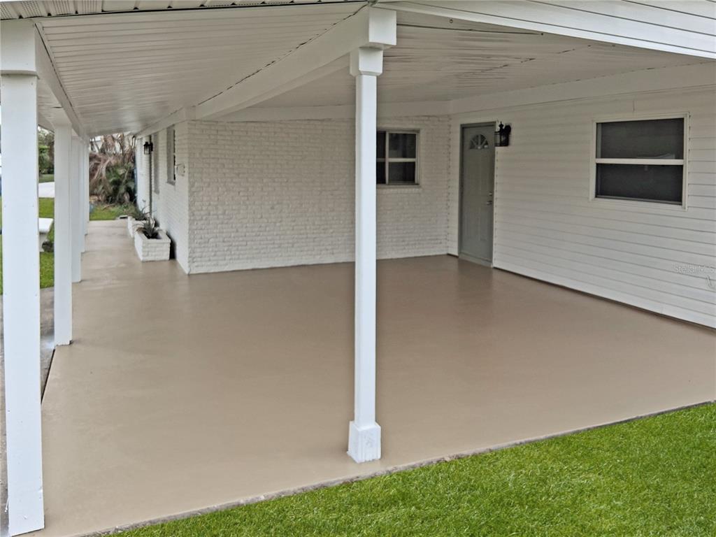 A covered concrete carport features white support columns and a white brick exterior wall — 430 SANTIAGO AVENUE, ORLANDO, FL