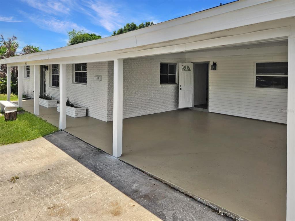 A white brick house features a large covered carport and a concrete driveway — 430 SANTIAGO AVENUE, ORLANDO, FL