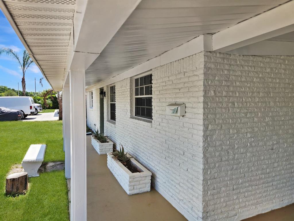 A white brick exterior wall features a covered porch with two matching brick planters — 430 SANTIAGO AVENUE, ORLANDO, FL