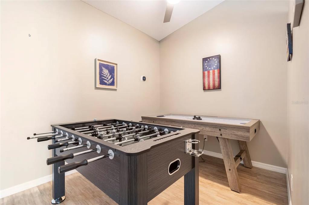 A game room features a foosball table, an air hockey table, and light-colored wood flooring — 2471 QUINCY AVENUE SE, PALM BAY, FL