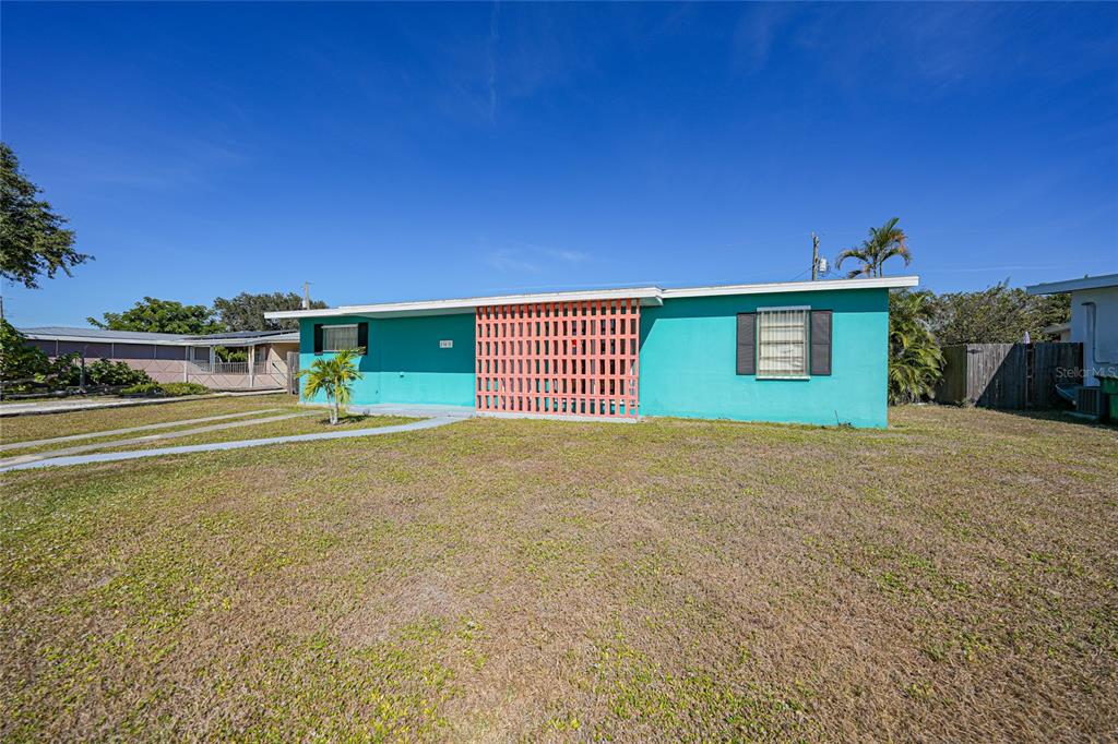 A teal, single-story house features a decorative orange breeze block screen on the front facade — 21470 EDGEWATER DRIVE, PORT CHARLOTTE, FL